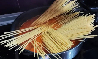 Шаг 6. Добавление в томатный соус воды и спагетти (Крок 6. Додавання в томатний соус води та спагеті)